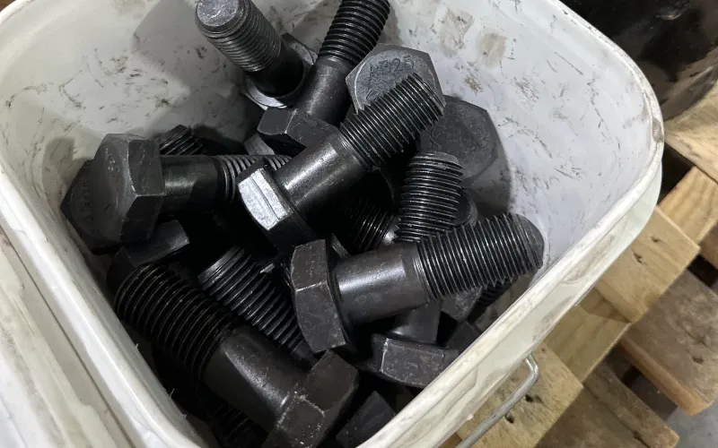 A large bucket of bolts in warehouse.